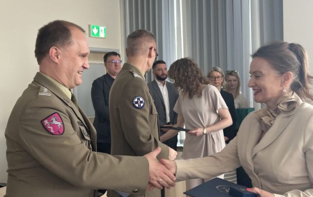 Studentka ściska rękę pracownikowi WIM-PIB ubranemu w wojskowy mundur.
