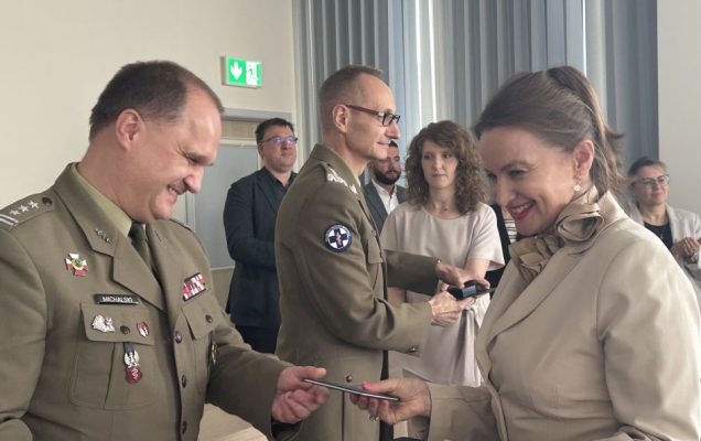 Studentka odbiera dyplom od pracownika WIM-PIB ubranego w wojskowy mundur.