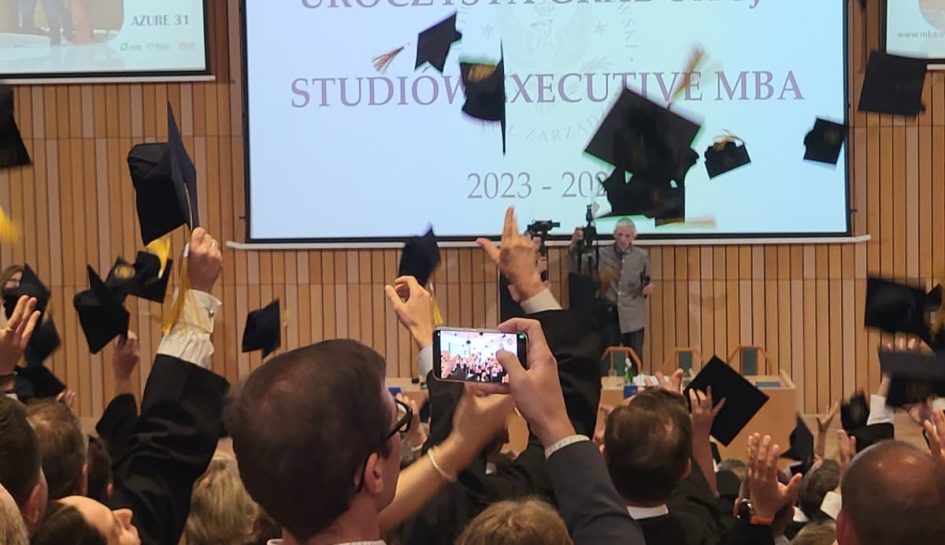 Studenci podrzucają czapki studenckie.