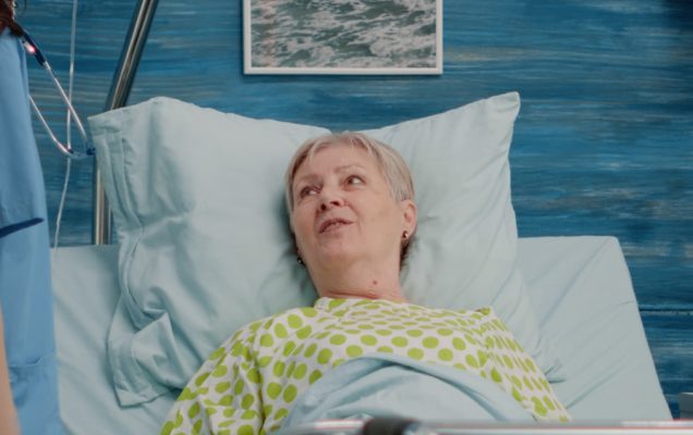 Starsza kobieta leżąca w łóżku szpitalnym