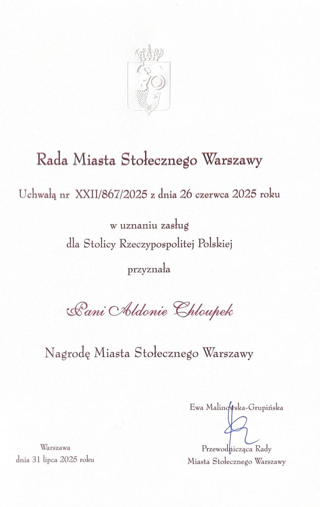 Dyplom dla Aldony Chloupek. Tekst dyplomu:" Rada Miasta Stołecznego Warszawy
Uchwałą nr XXII/867/2025 z dnia 26 czerwca 2025 roku w uznaniu zasług
dla Stolicy Rzeczypospolitej Polskiej przyznała 
Pani Aldonie Chloupek Nagrodę Miasta Stołecznego Warszawy
Ewa Malińska-Grupińska Warszawa Przewodnicząca Rady
dnia 31 lipca 2025 roku Miasta Stołecznego Warszawy Miasta Stołecznego Warszawy Uchwałą nr XXII/867/2025 z dnia 26 czerwca 2025 roku
w uznaniu zasług dla Stolicy Rzeczypospolitej Polskiej
przyznała Nagrodę Miasta Stołecznego Warszawy Ewa Malin ska-Grupińska
Warszawa Przewodnicząca Rady
dnia 31 lipca 2025 roku Miasta Stołecznego Warszawy."