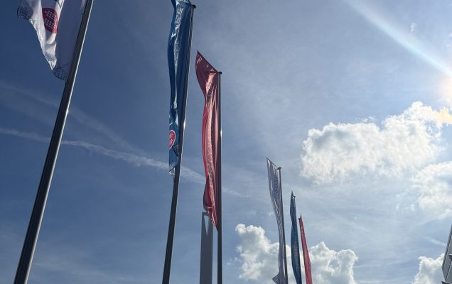 Maszty z flagami przed centrum konferencyjnym.