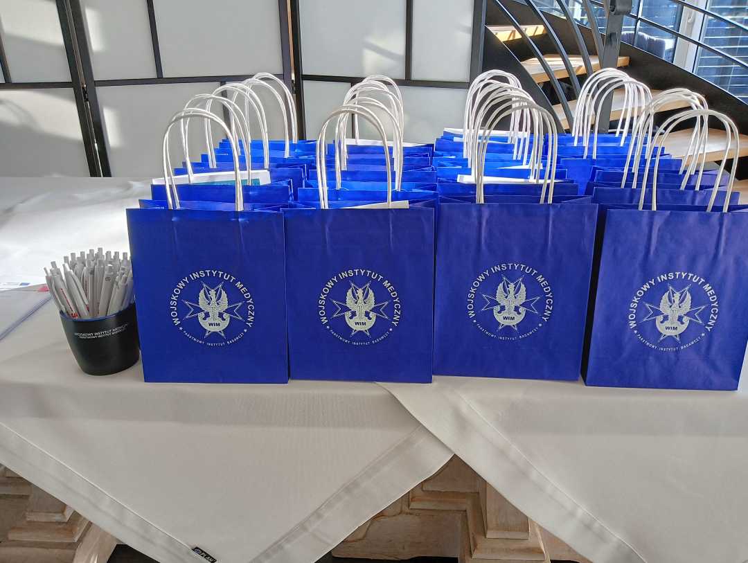 Niebieskie torby prezentowe z logo WIM-PIB na stole.