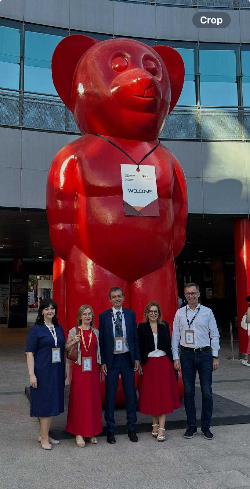 Naukowcy z WIM obok rzeźby czerwonego niedźwiedzia stojącego na dwóch łapach z logo ESC i napisem kongresu na szyi.