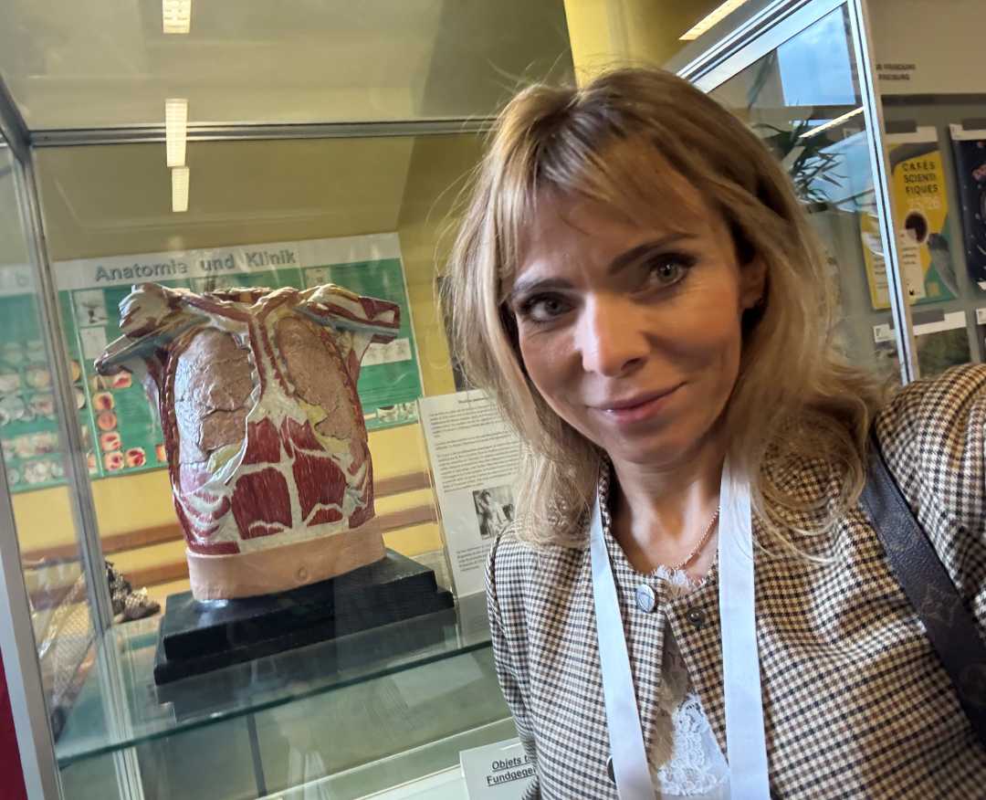 Katarzyna Gniadek Olczak za nią model medyczny klatki piersiowej w szklanej witrynie.