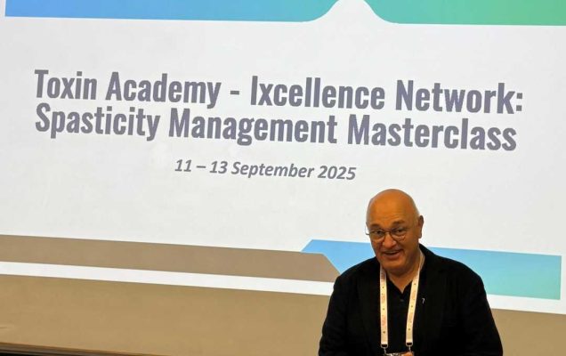 Profesor Serder Kocer podczas wykładu. Za nim plansza z nazwą kursu Spasticity Management Masterclass.