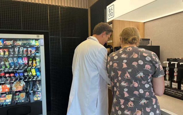 Kobieta i mężczyzna w średnim wieku korzystają z ekspresu do kawy.