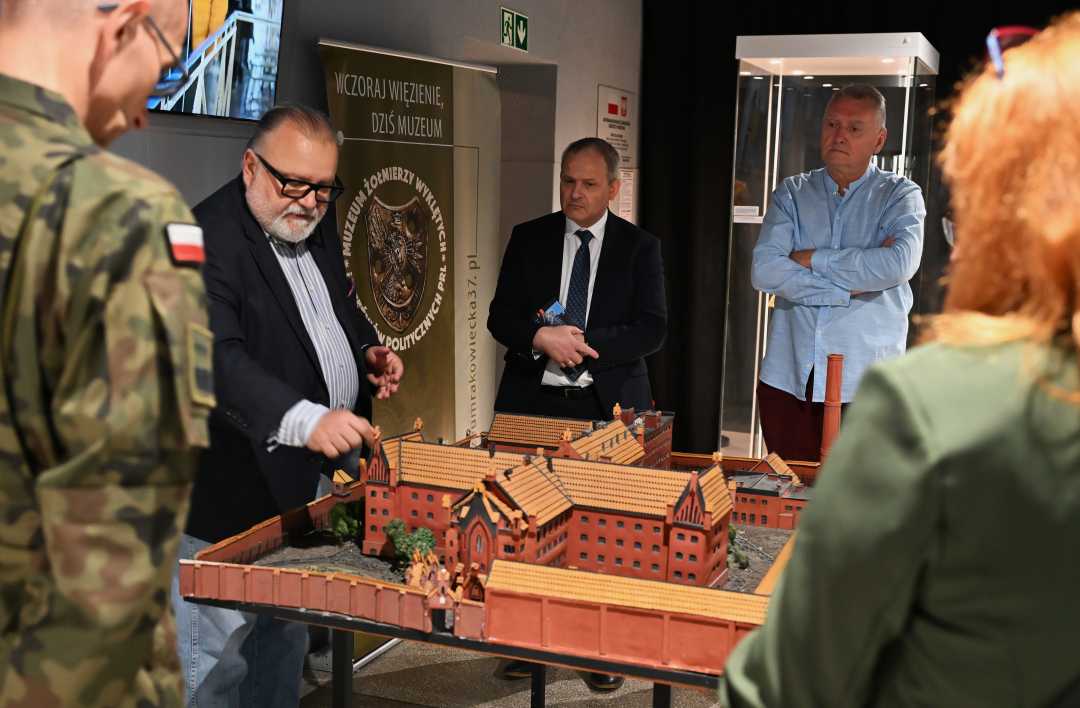 Pracownicy WIM w sali Muzeum Żołnierzy Wyklętych oglądają makietę budynku.