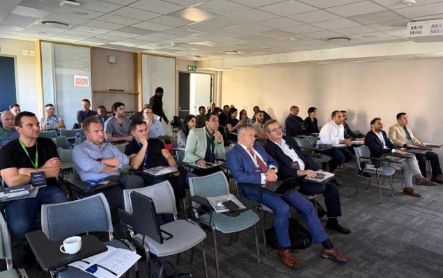 Słuchacze słuchający szkolenia na sali wykładowej.