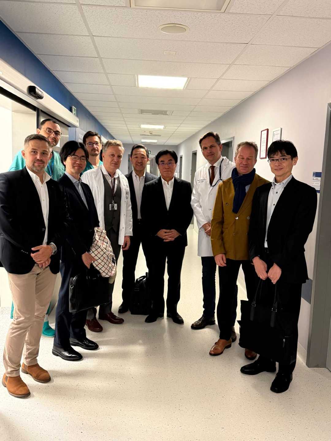 Zdjęcie grupowe delegacji z Japonii z lekarzami WIM na korytarzu szpitalnym.
