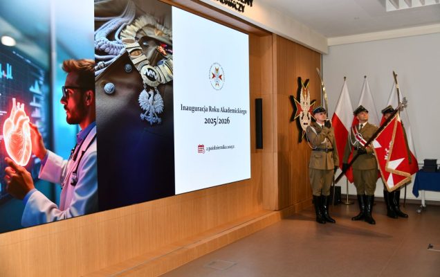 Aula WIM-PIB, trzech żołnierzy w mundurach galowych stoi na baczność z sztandarem Polski, obok nich wyświetlony napis Inauguracja Roku Akademickiego 2025/2026.