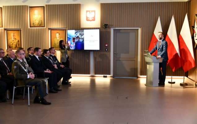 Pracownicy i goście siedzący na auli WIM słuchają przemówienia Władysława Kosiniaka-Kamysza stojącego przy mównicy.