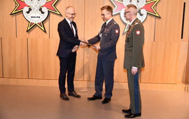 prof. Grzegorz Gielerak i prof. Paweł Krzesiński wręcza dyplom habilitacyjny Piotrowi Dąbrowieckiemu.