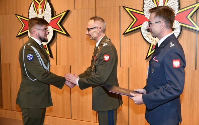 prof. Grzegorz Gielerak i prof. Paweł Krzesiński wręczają dyplom doktorski kapitanowi lekarzowi Pawłowi Rozbickiemu.