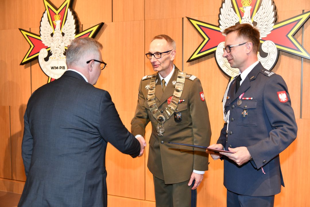 prof. Grzegorz Gielerak i prof. Paweł Krzesiński wręczają dyplom doktorski Hubertowi Burdziakowi.
