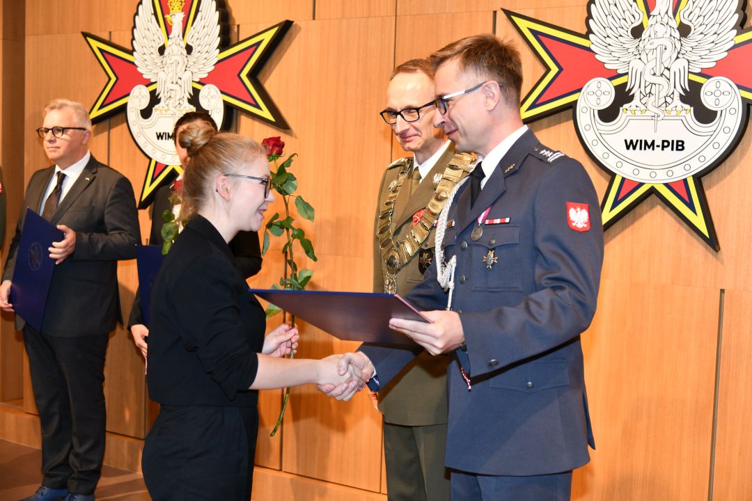 prof. Grzegorz Gielerak i prof. Paweł Krzesiński wręczają dyplom doktorski magister Wanesie Wilczyńskiej.