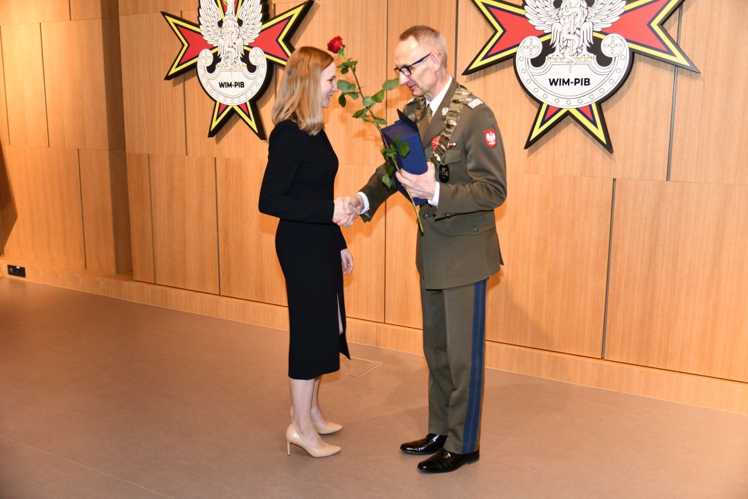 Dyrektor WIM wręcza nagrodę czerwoną różę doktor Marcie Mielniczuk.