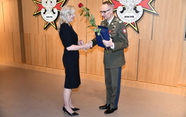 Dyrektor WIM wręcza nagrodę czerwoną różę lekarz Justynie Sabeli.