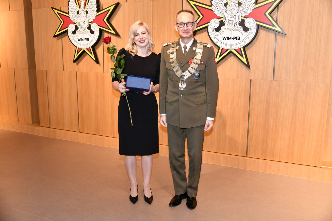 Dyrektor WIM pozuje z lekarz Justynie Sabeli trzymającą nagrodę oraz czerwoną różę