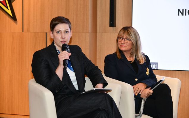 Dwie prelegentko podczas panelu, jedna z nich trzyma mikrofon w dłoni.