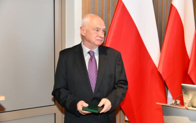 Jeden z prelegentów z odznaczeniem w dłoniach.
