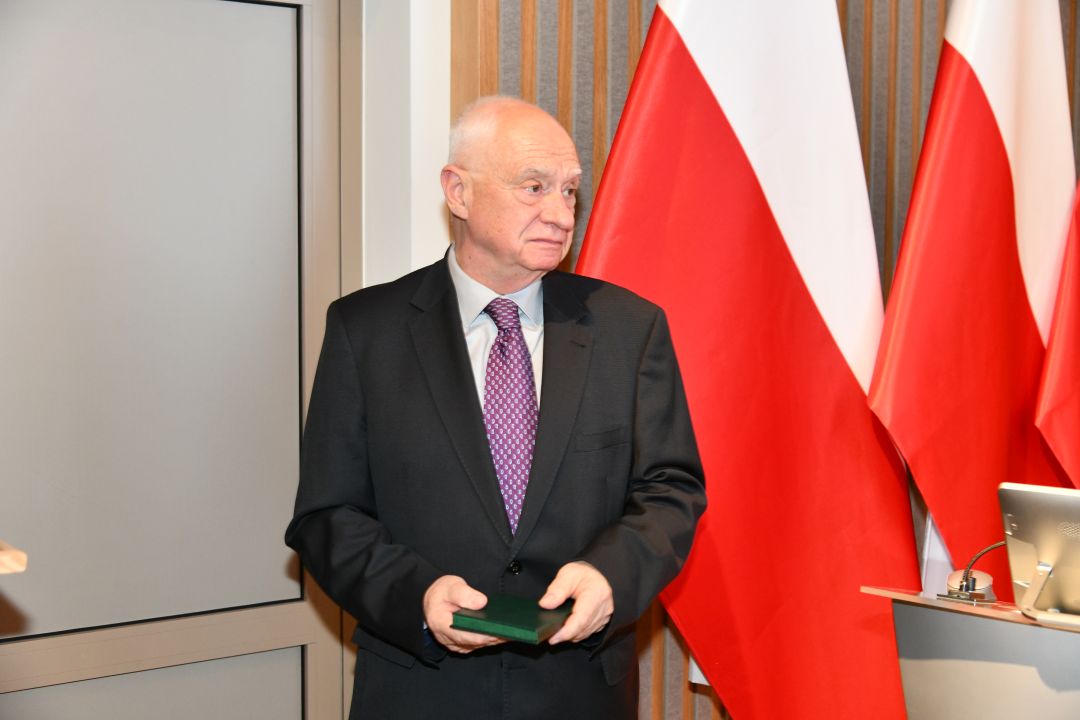 Jeden z prelegentów z odznaczeniem w dłoniach.