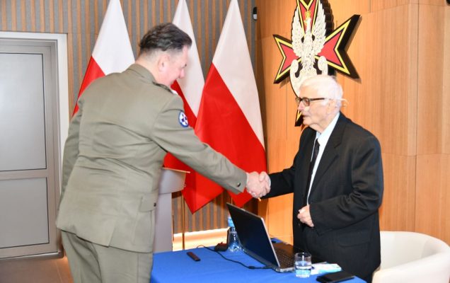 Radosław Tworus ściska rękę prelegentowi.