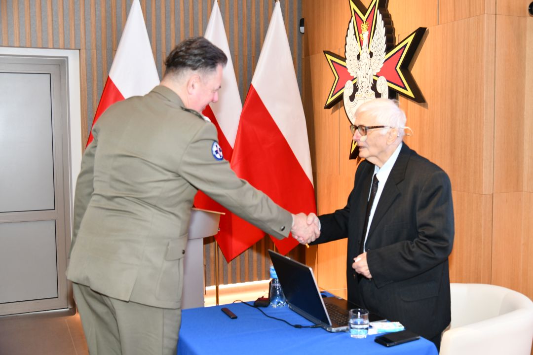 Radosław Tworus ściska rękę prelegentowi.