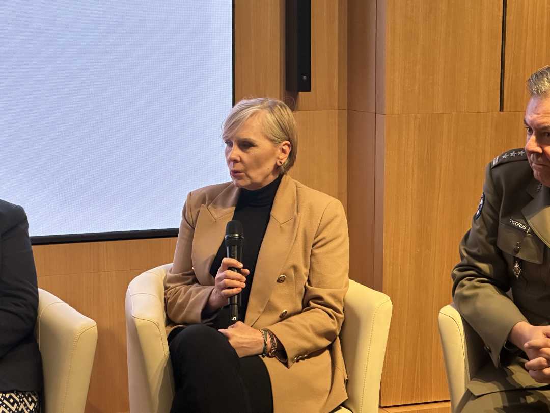 Prelegentka podczas panelu. Kobieta siedzi w fotelu trzymając mikrofon w dłoniach.