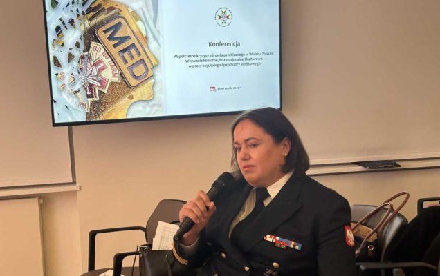 Prelegentka podczas panelu. Kobieta siedzi w fotelu trzymając mikrofon w dłoniach.