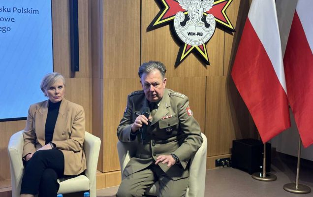 Radosław Tworus siedzi w fotelu mówiąc do mikrofonu.