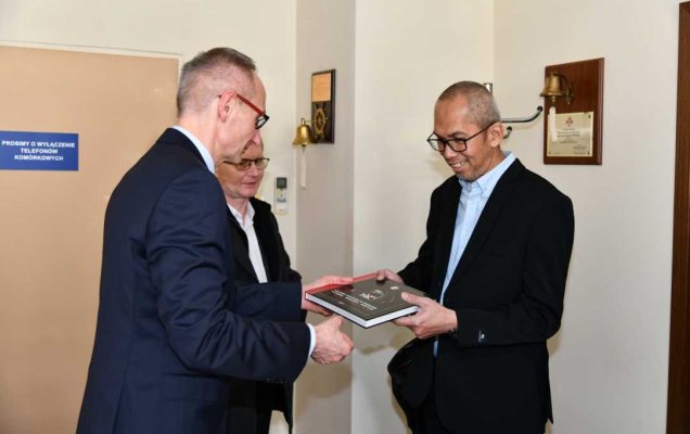Dyrektor WIM wręcza jednemu z delegatów pamiątkowy album.