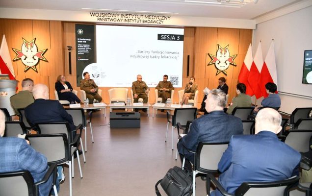 Zdjęcie uczestników podczas panelu konferencji, ujęcie z tyłu sali.