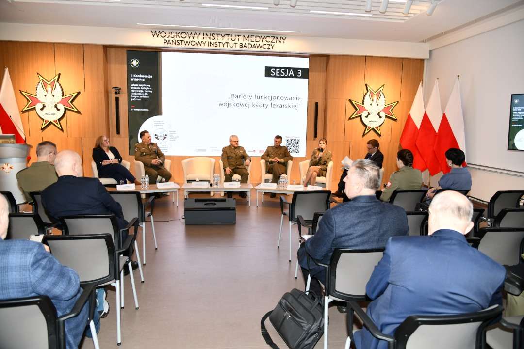 Zdjęcie uczestników podczas panelu konferencji, ujęcie z tyłu sali.