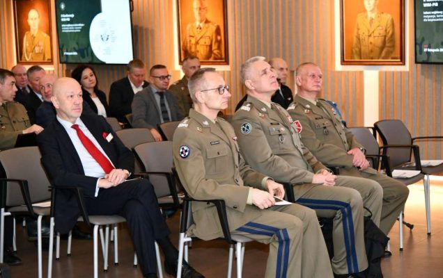 Słuchacze konferencji siedzący na auli Wojskowego Instytutu Medycznego. Na pierwszym planie Dyrektor WIM-PIB Grzegorz Gielerak.