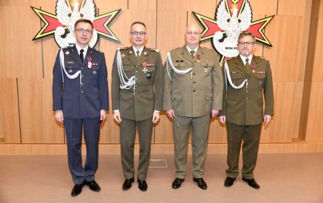 Dyrektor WIM pozuje do zdjęcia z pracownikami.