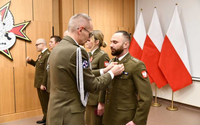 Dyrektor WIM wręcza odznaczenie.