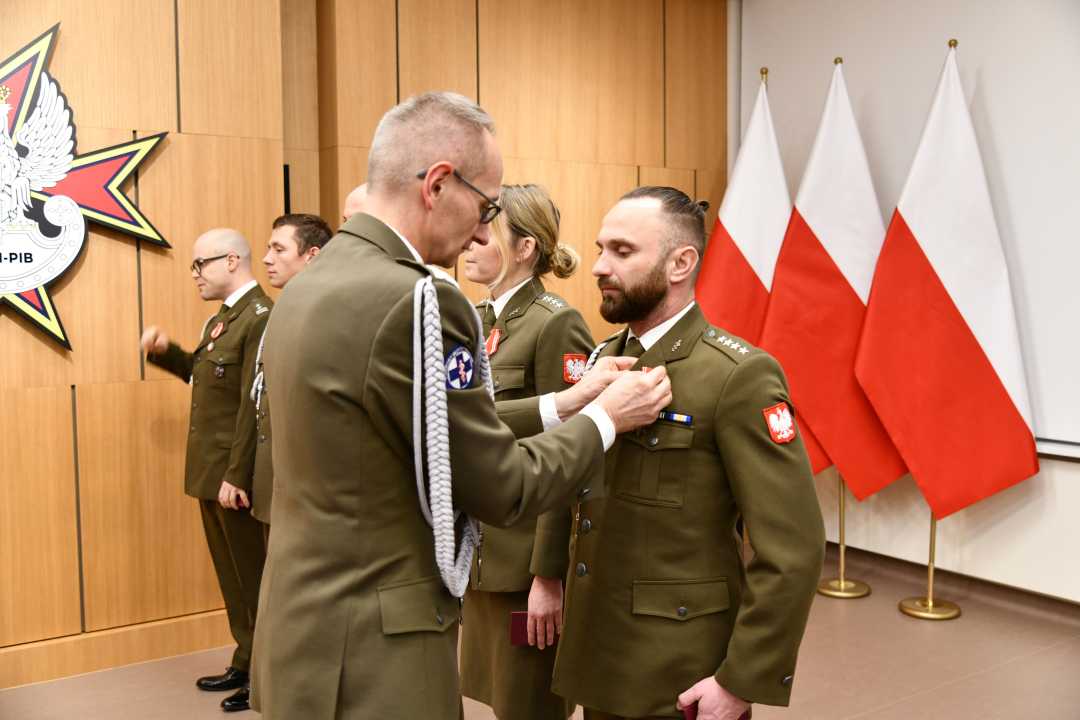 Dyrektor WIM wręcza odznaczenie.