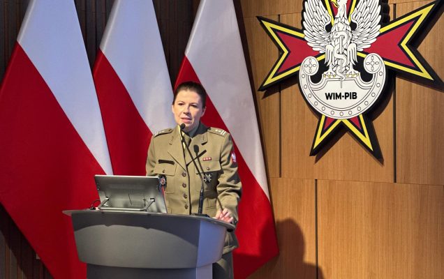Panelistka przy mównicy, za nią logo WIM i flagi Polski.