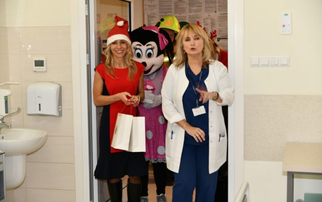Pomocnicy świętego Mikołaja z prezentami wchodzą do sali szpitalnej.