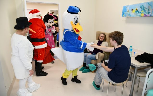Święty Mikołaj i jego pomocnicy odwiedzają salę nastoletnich pacjentów.