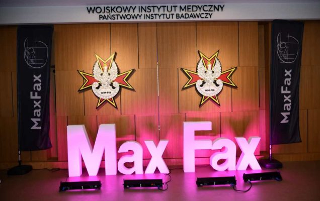Podświetlony napis Max Fax na auli WIM. Za napisem na ścianę 2 logotypy WIM-PIB.