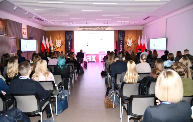 Ujecie z tyłu sali siedzących słuchaczy.