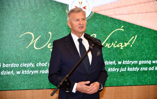 Podsekretarz Stanu w Ministerstwie Obrony Narodowej, Pan Stanisław Wziątek przemawia na auli WIM. Za jego plecami na ekranie wyświetlone życzenia bożonarodzeniowe.