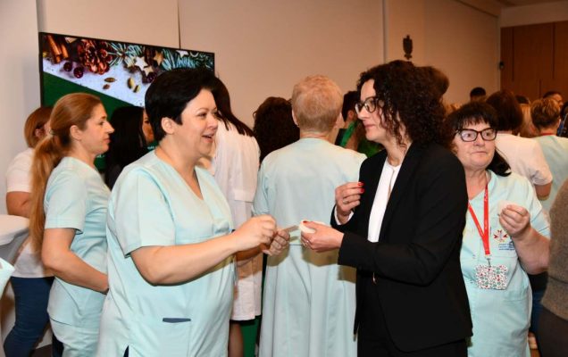 Goście i pracownicy dzielą się opłatkiem.