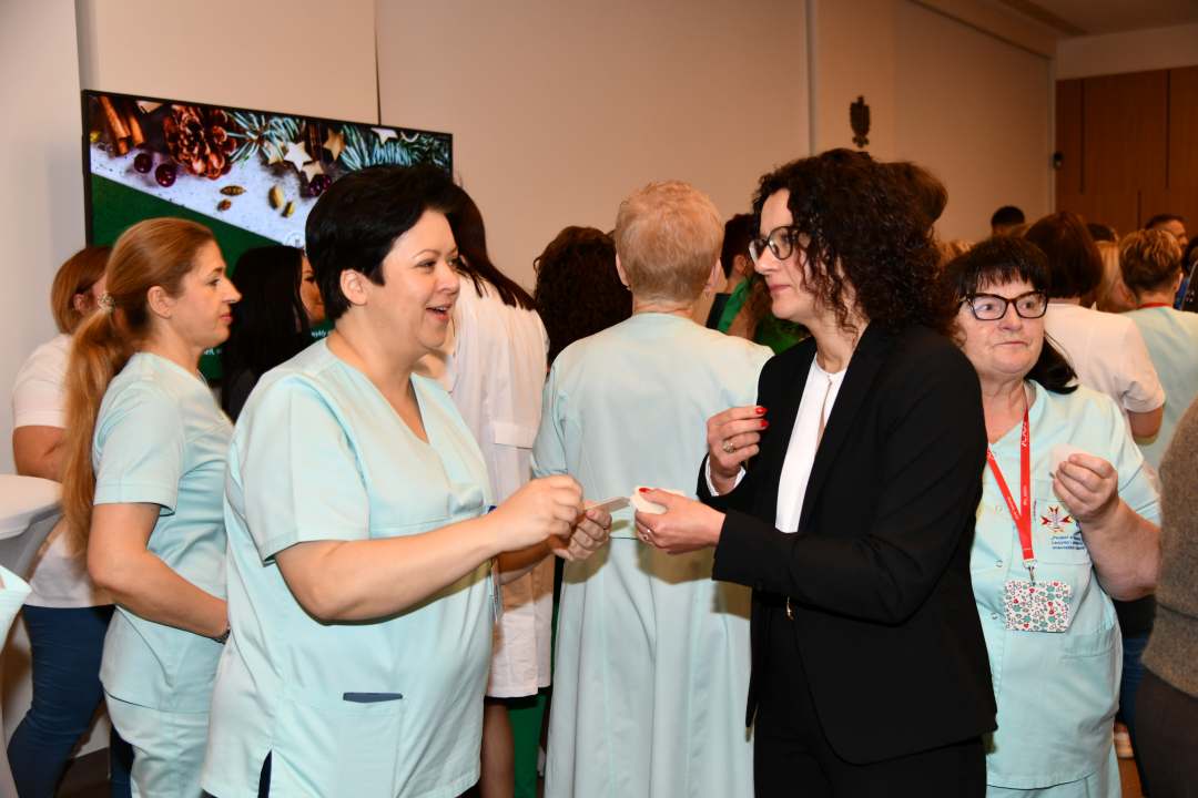 Goście i pracownicy dzielą się opłatkiem.