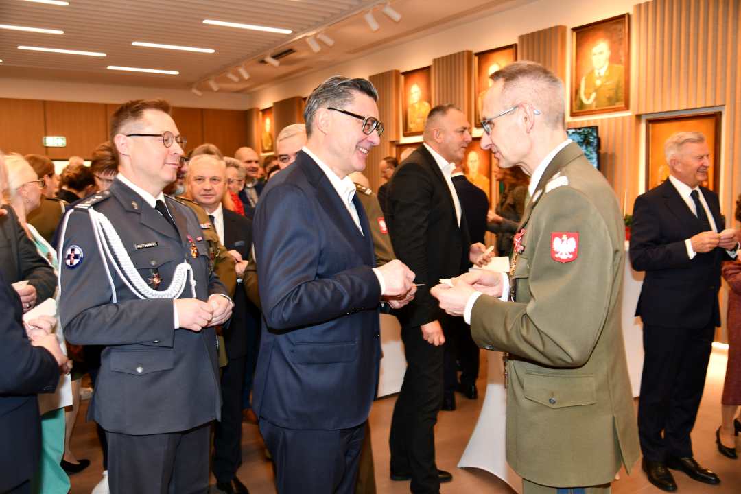 Dyrektor WIM dzieli się opłatkiem z pracownikami i gośćmi.