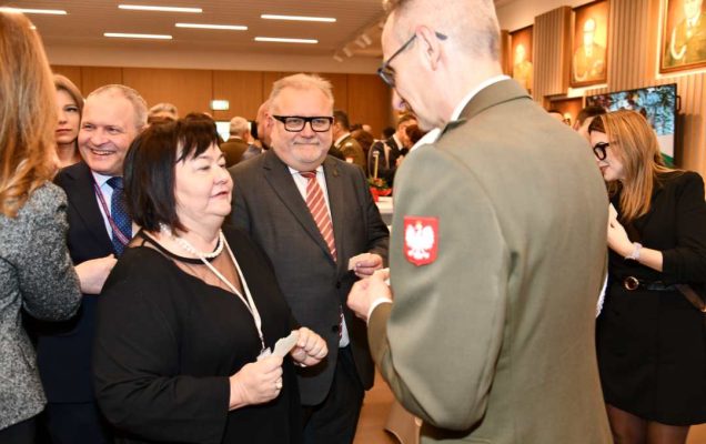 Dyrektor WIM dzieli się opłatkiem z pracownikami i gośćmi.