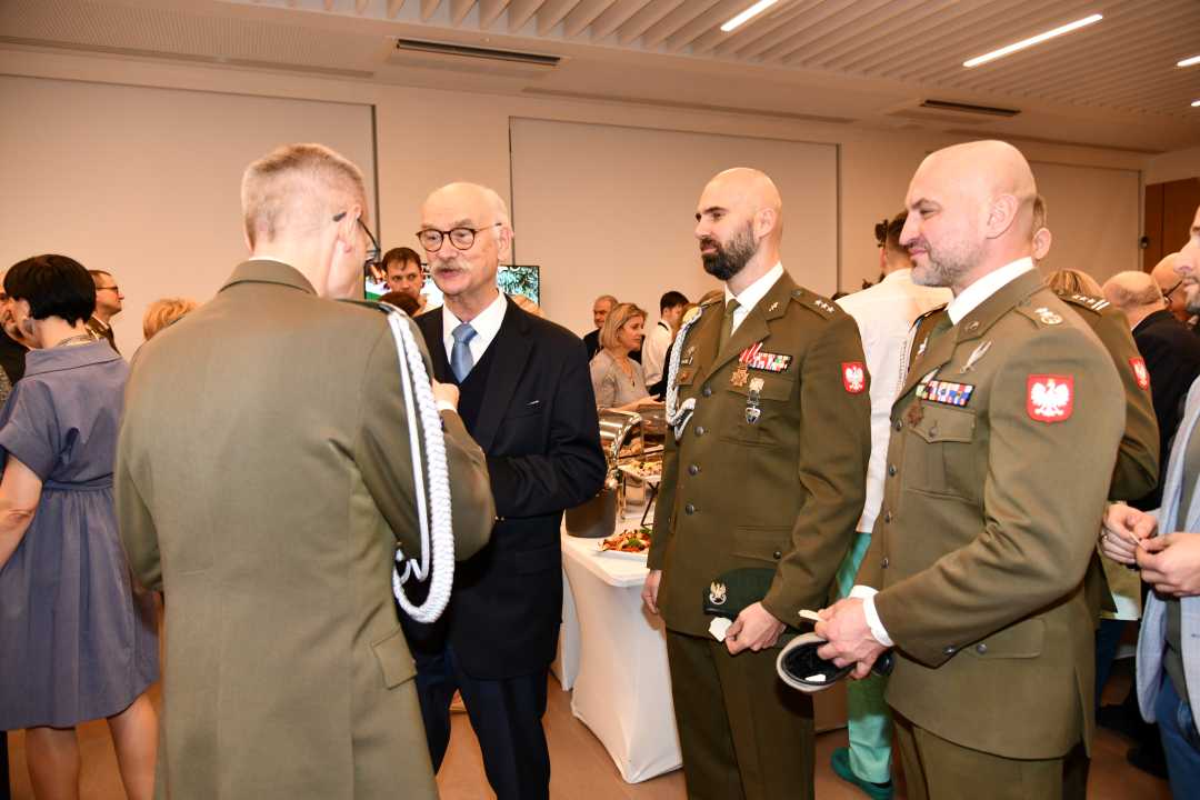 Dyrektor WIM dzieli się opłatkiem z pracownikami i gośćmi.