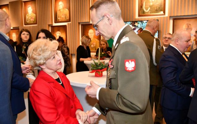 Dyrektor WIM dzieli się opłatkiem z pracownikami i gośćmi.